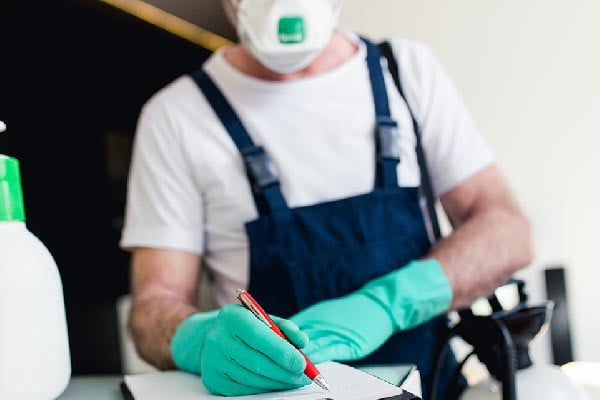 A Fraleigh pest control employee filling out paperwork.